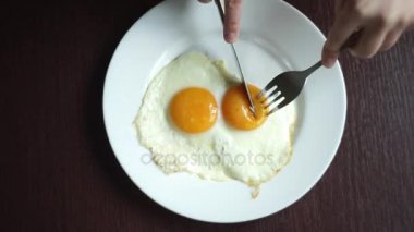 Bıçak ve çatal tahta masada beyaz tabakta ile kesme kızarmış yumurta