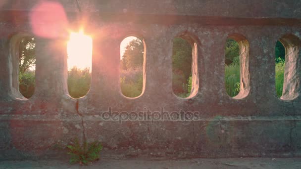 Männerbeine, die durch Sonnenstrahlen gehen. Strahlende Sonne durch alte Brücke — Stockvideo