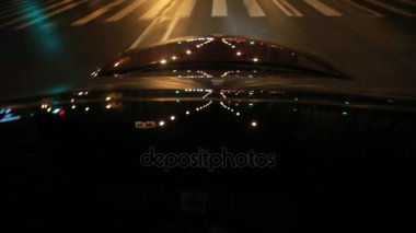 Çatı ve gece şehirde hareketli otomatik kaputunun üzerinde ışık yansımaları