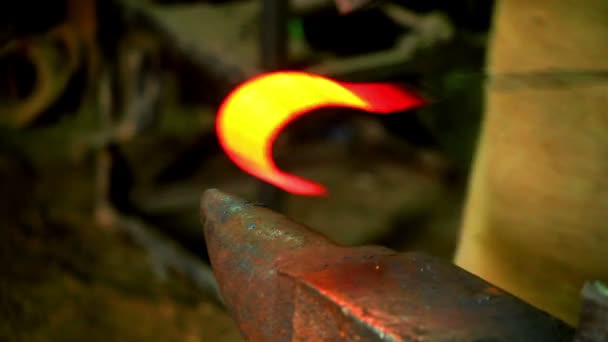 Schmied, der rotglühendes Eisen in Haken auf Amboss formt. Heißes Metall auf Amboss in der Werkstatt — Stockvideo