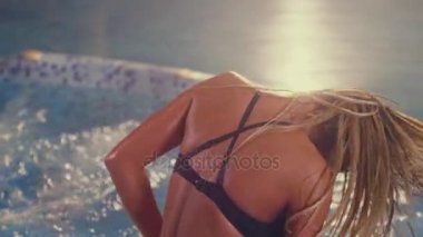 Seksi kadın yüzme havuzunda. Sarışın kız ıslak saç sallayarak. Havuz partisi