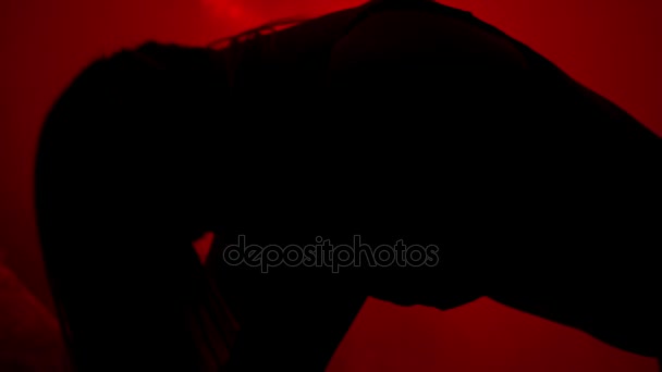 Σιλουέτα της γυναίκας τίναγμα μαλλιών σε κόκκινο φόντο. Σέξι κορίτσι silhouette στο σκοτάδι — Αρχείο Βίντεο