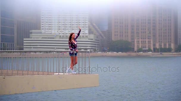 Una chica agitando a alguien en el mar. Joven hermosa mujer saludando adiós — Vídeos de Stock