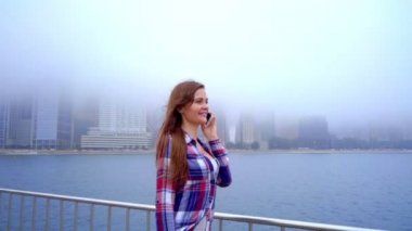 Cep telefonu üzerinde konuşurken ve gülümseyen genç güzel kadın. Telefon konuşma