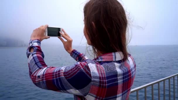 Mulher bonita nova que faz a foto móvel da cidade moderna no nevoeiro — Vídeo de Stock