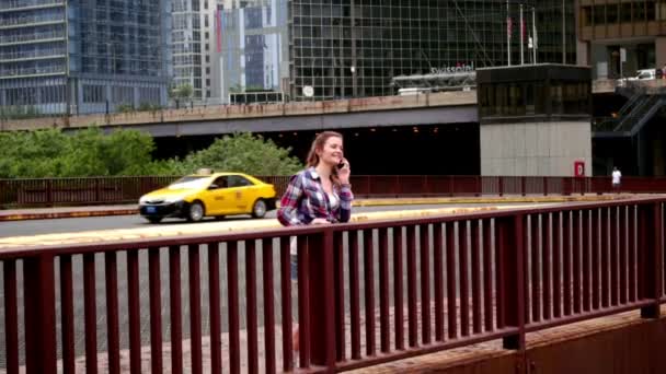 Mooie jongedame pratende telefoon. Vrouw spreken telefoon op brug stad — Stockvideo