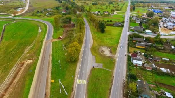 Drone vista della costruzione di strade suburbane. Camion merci che guidano su strada di campagna — Video Stock