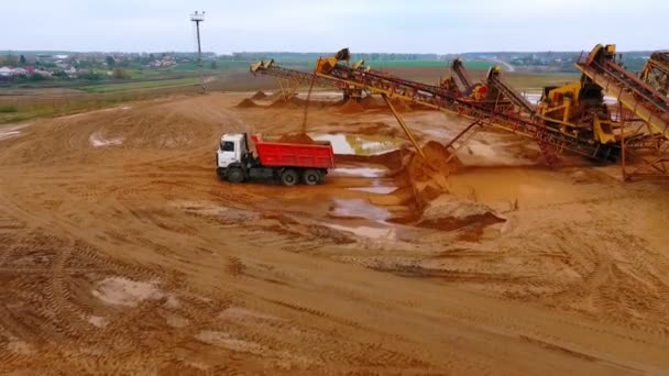 Drone vista do transportador de mineração despeje areia no caminhão basculante. Máquinas para mineração — Vídeo de Stock