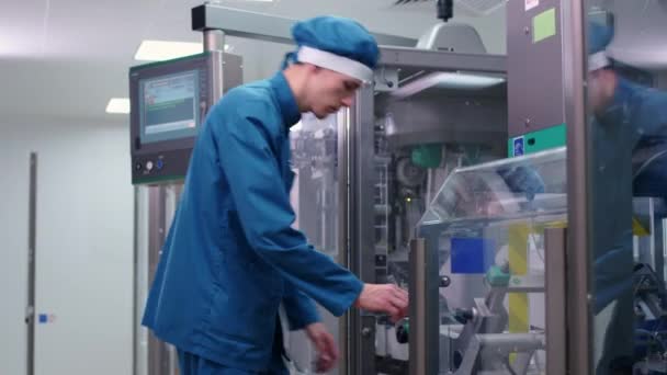 Fabricación de envases. Hombre de fábrica trabajando en la máquina de embalaje — Vídeo de stock