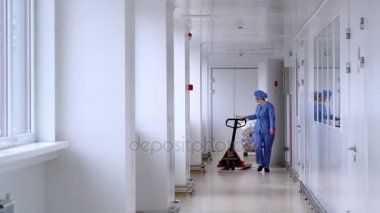 Boş palet Asansör beyaz koridorda hareketli depo işçisi. Paletli taşıma