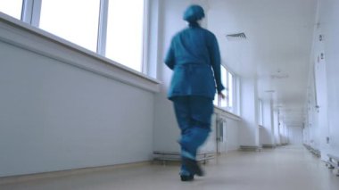 Tek tip geri beyaz koridorda görünümü çalışan kadın. Acil iş