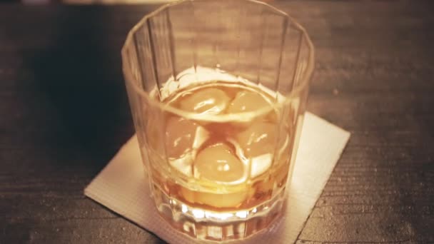 Verter la cola en un vaso con hielo. Un vaso de whisky. Whisky cola. Líquido de whisky — Vídeos de Stock