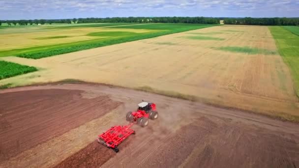 Tracteur agricole avec remorque pour labourer debout sur un champ cultivé 
