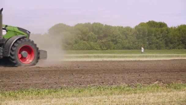 De trekker van de landbouw in het veld. Landbouw machines over geploegd veld werken — Stockvideo