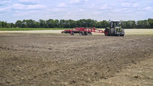 Mezőgazdasági traktor plowing mező. Folyamat plowing szántóföldi mező. Szántott föld — Stock videók
