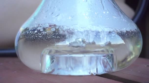 Φυσαλίδες αέρα σε διαφανές ποτήρι νερό φιάλη για κάπνισμα ναργιλέ — Αρχείο Βίντεο