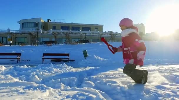 Άποψη πλευρά λίγο κορίτσι να τρέχει στο χειμερινό πάρκο. Ηλιόλουστη χειμωνιάτικη ημέρα — Αρχείο Βίντεο