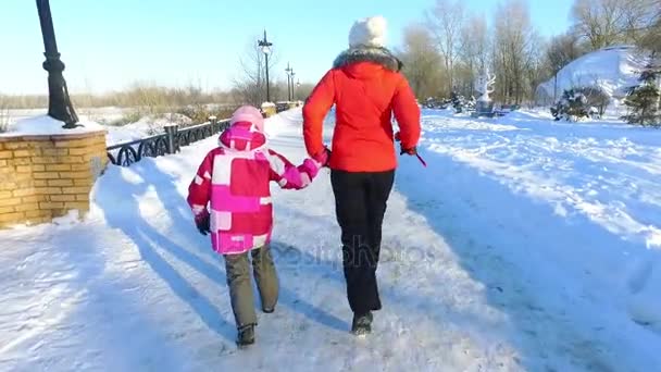 后视图母亲和女儿在冬季公园跑步。快乐的冬天 — 图库视频影像