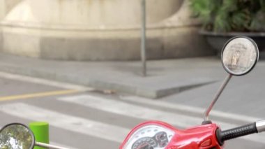 Caddenin üzerinde kırmızı vintage scooter duran. Retro scooter citystreet üzerinde otopark