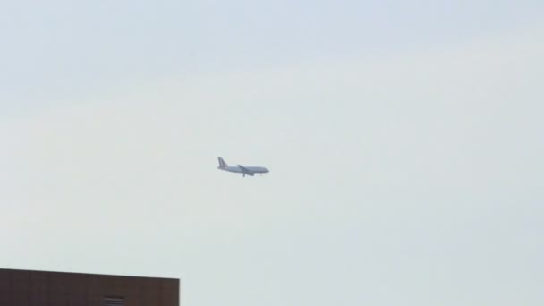 Plane flying over city. Passenger airplane flying. Aircraft fly over city — Stock Video