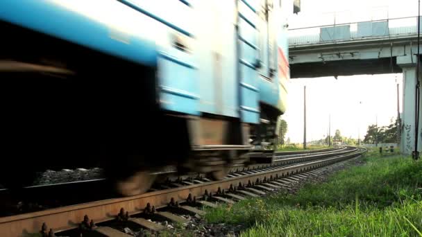 Comboio eléctrico em movimento na estrada de ferro. Comboio de passageiros em movimento sob ponte de carro — Vídeo de Stock