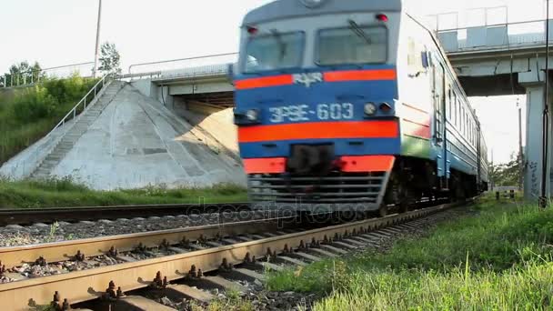 Comboio elétrico movendo-se na estrada de ferro sob ponte de carro. Trem moderno no caminho de ferro — Vídeo de Stock