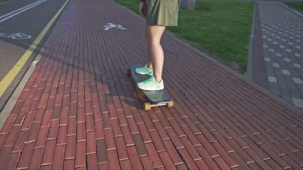 Pohled zezadu mladá žena, ježdění na skateboardu. Zpomalený pohyb venku skateboardingu — Stock video