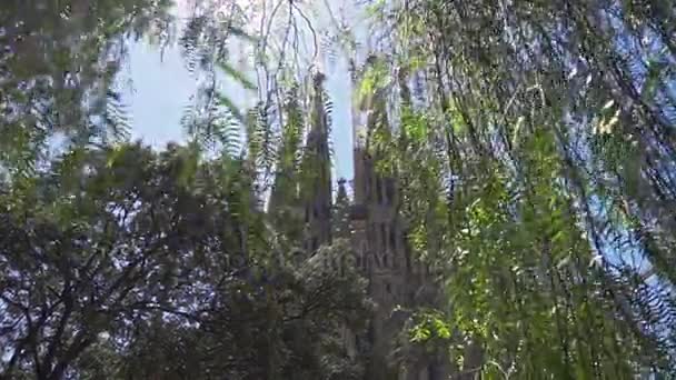Antigua iglesia católica en hojas de árbol. Edificio histórico de Antonio Gaudí — Vídeos de Stock