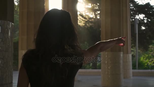 Young woman pointing with her hand away. Girl walking outdoors at sunset — Stock Video