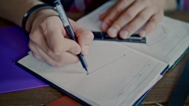 Erkek el kroki not defterinde çizim. Adam kalemi ve cetvel çizgi çekerek