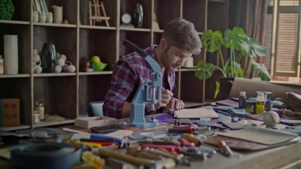 Designer travaillant sur le croquis de produits en cuir à la maison. Cuir homme pensée — Video