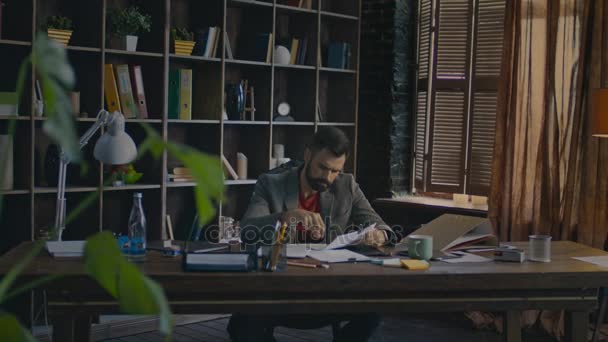 Empresário a ler documentos na secretária. Empresário que trabalha no escritório em casa — Vídeo de Stock