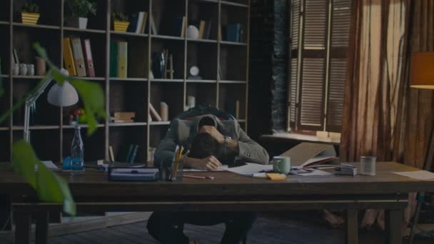 Hombre de negocios cansado tumbado en el escritorio de la oficina. Hombre exaustado en el escritorio en el lugar de trabajo — Vídeo de stock