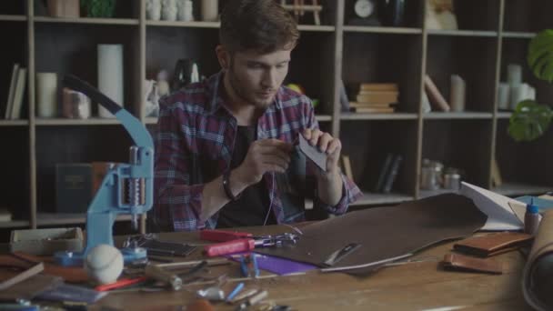 Artesano costura cartera de cuero con aguja en el taller en casa — Vídeo de stock