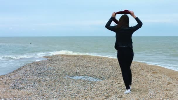 Mujer joven caminando en la playa de arena en el fondo mar ola y salpicadura — Vídeos de Stock