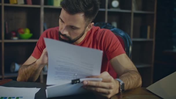 Jeune homme d'affaires lisant des documents au bureau. Papier au bureau le soir — Video