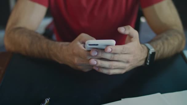 Manos masculinas usando teléfono. Primer plano del mensaje de mecanografía de mano masculina en el iphone en la oficina — Vídeos de Stock