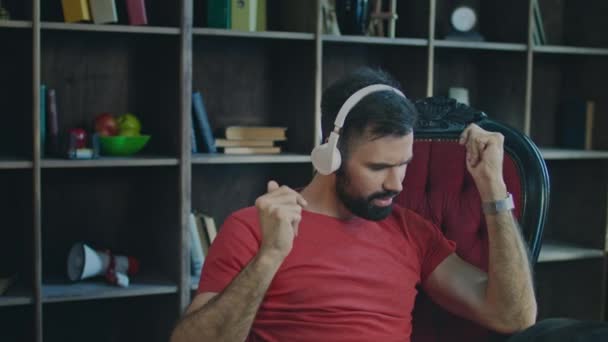 Hombre de negocios bailando en silla. Joven escuchando música en auriculares — Vídeos de Stock