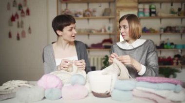 İki kadın arkadaş iş Studio yün iplik örgü eğlenin. Kadın eğlence