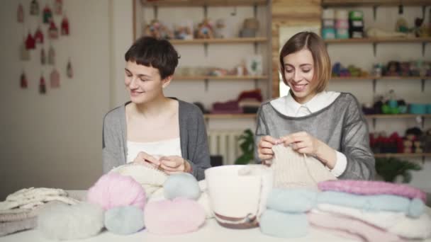 Dwie kobiety knitter mówi i uśmiecha się do tabeli pracy w studio — Wideo stockowe