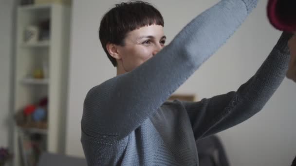 Jeune femme portant un chapeau de sœur à la maison. Portrait de fille hipster ajustement chapeau de laine — Video