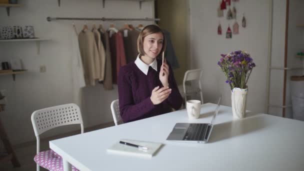 Mujer de negocios que trabaja en el lugar de trabajo. Mujer joven llamando en el teléfono móvil — Vídeo de stock