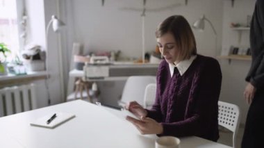 Masada oturan ve evde tablet pc birlikte arkadaş kullanarak genç kadın