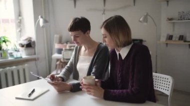 Ana sayfa online eğitim için tablet bilgisayar kullanan iki kadın öğrenciler