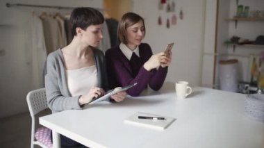 İki genç kadın tablet pc ve cep telefonu online alışveriş için kullanma