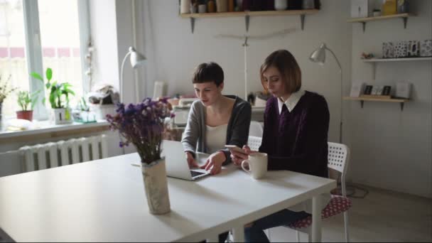 Deux jeunes femmes assises à table et utilisant un ordinateur portable pour commander en ligne — Video