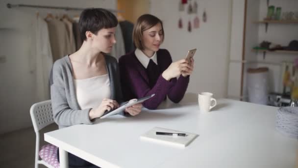 Duas jovens usando tablet pc e telefone celular para compras on-line — Vídeo de Stock