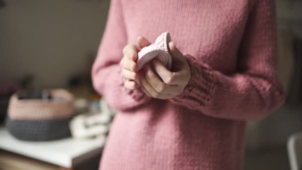 Mains féminines montrant des chaussons tricotés pour bébés. Chaussures tricotées à la main pour bébé — Video