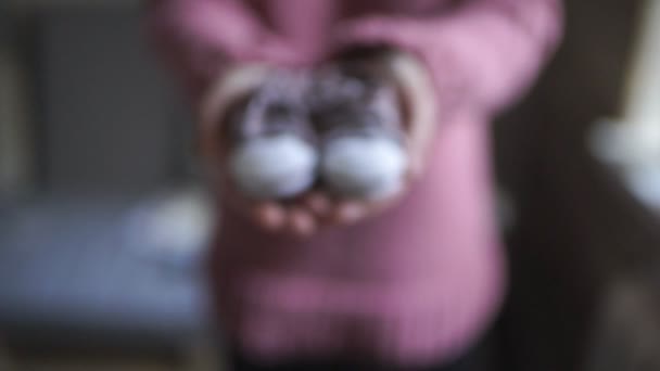 Kvinna händerna visar baby tossor. Stickad skor för barn — Stockvideo