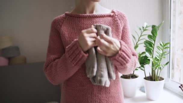 Female hands holding knitted clothes for baby. Mother expecting baby — Stock Video